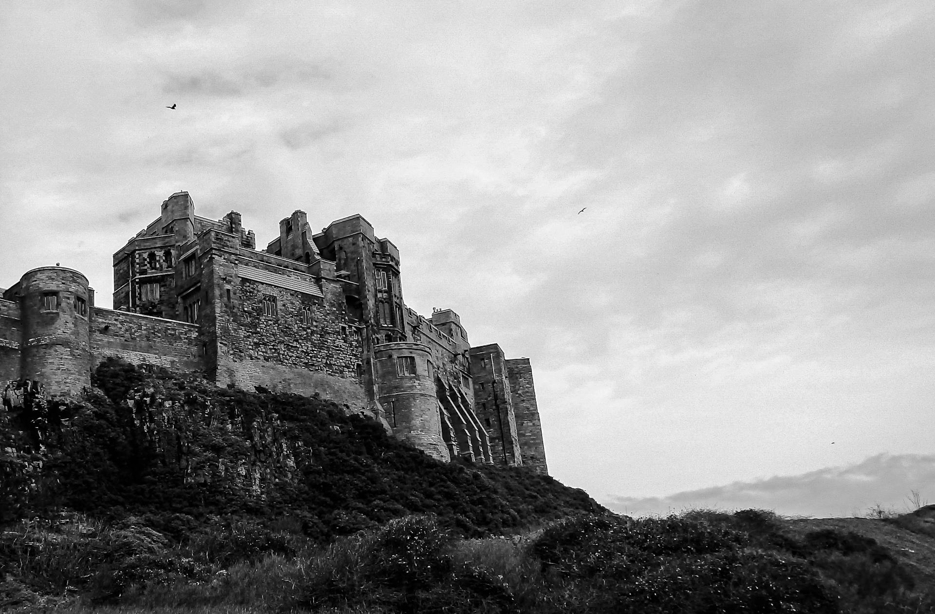 Grayscale Photo of Bamburgh Castle