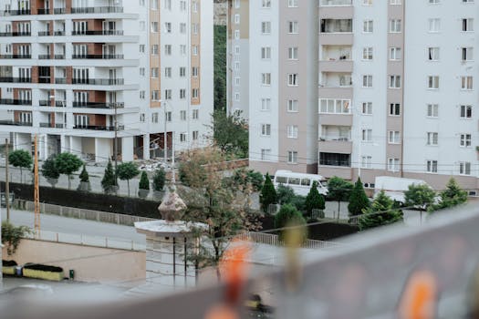 A cityscape view of modern residential buildings with greenery and urban streets.