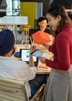 Diverse team in a modern office working with laptops and tablets during a creative meeting.