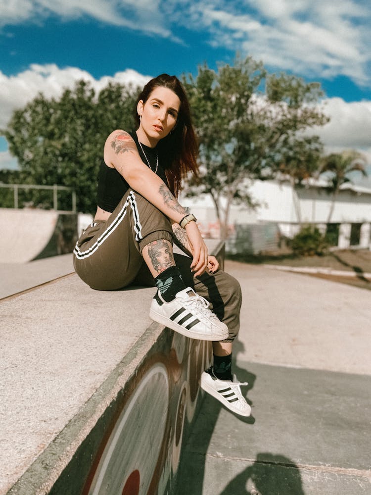 Young Hipster Tattooed Woman Sitting On Skate Ground