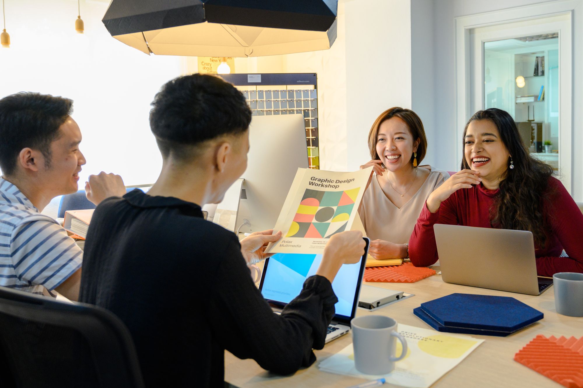 A diverse creative team sharing a cheerful moment during a relaxed working session.