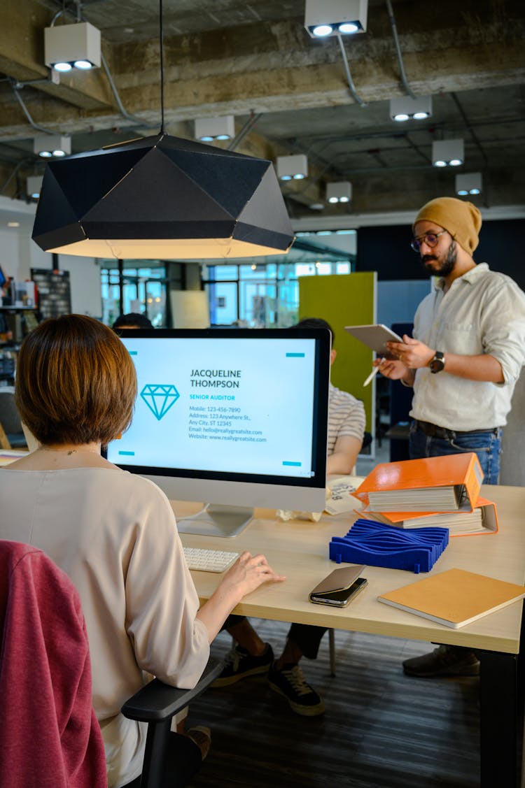 Man Standing At The Side Wearing Brown Bonnet Holding An Ipad And Apple Pencil 