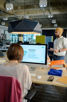 A professional office setting with a bearded employee presenting ideas on a tablet.