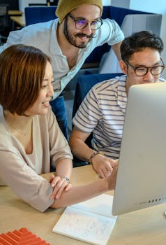 Diverse team collaborating at work, engaged and smiling in a modern office environment.