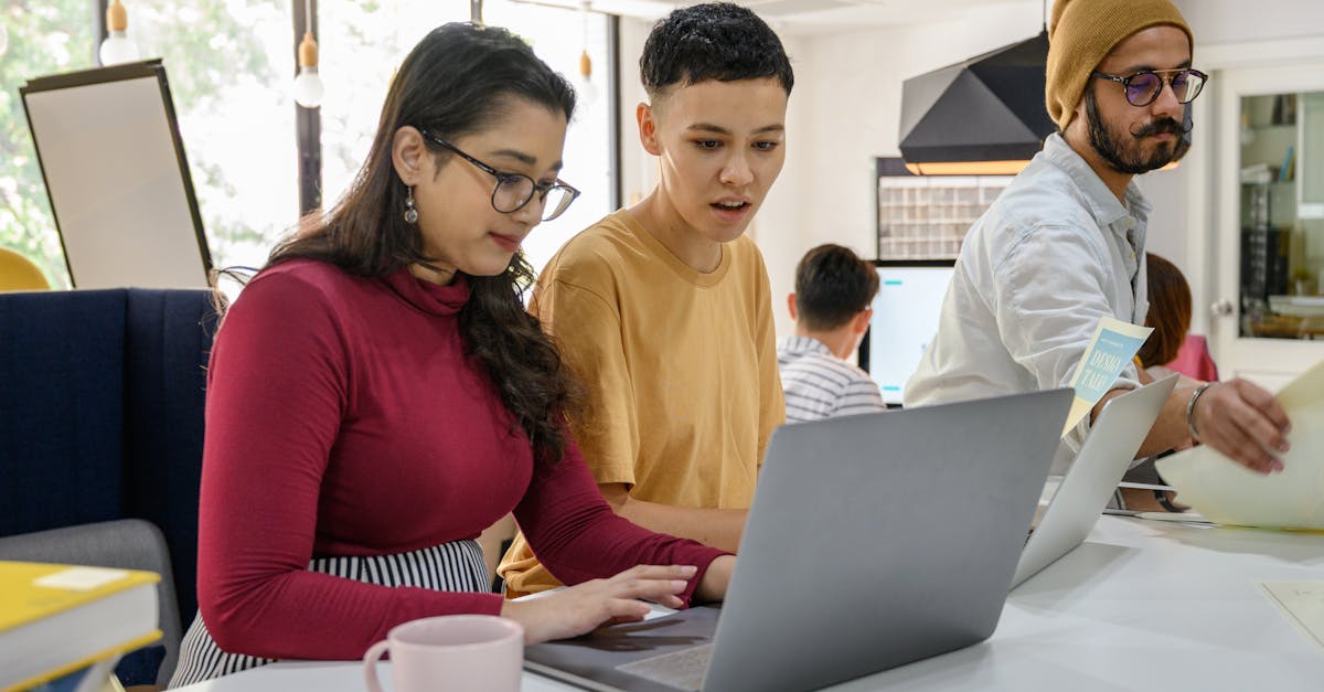 Diverse team of young developers in a collaborative meeting space with laptops