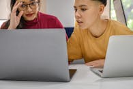 两个人在室内通过笔记本电脑密切合作处理一个项目