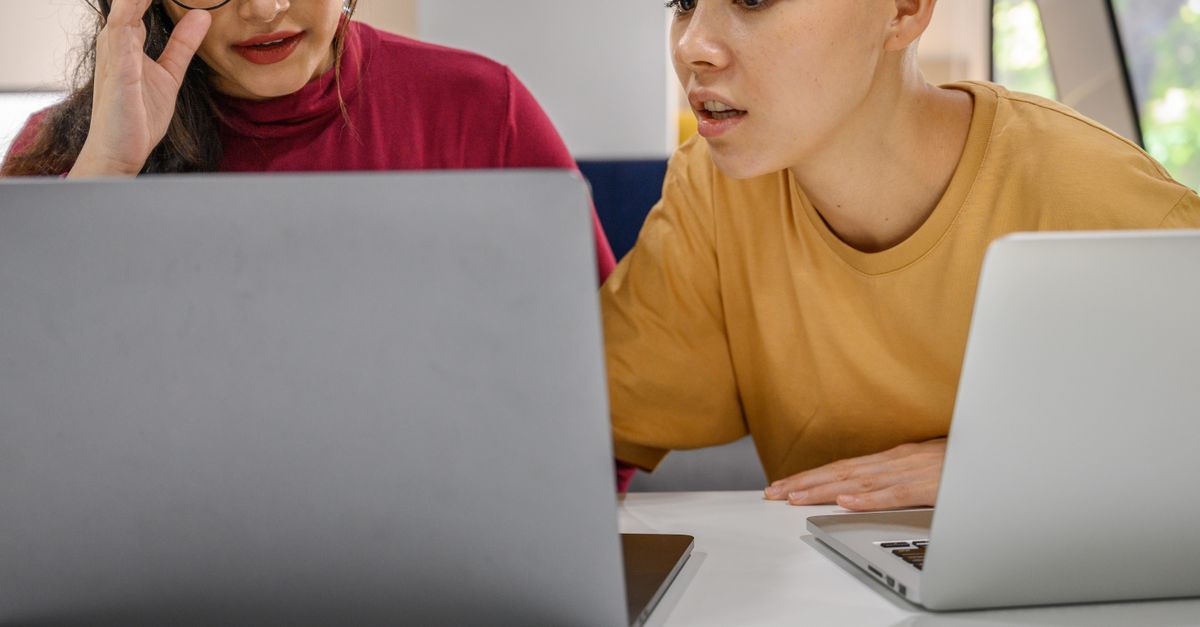 Two People Using a Laptop · Free Stock Photo