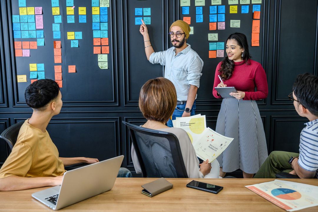 Team planning a project with sticky notes on a wall