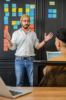 A bearded man discussing ideas with colleagues in an office setting.
