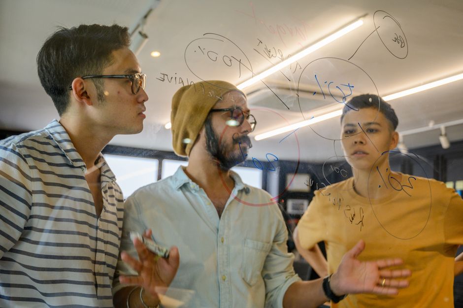 Des fondateurs collaborent autour d'un tableau en verre pour planifier leurs expériences de croissance