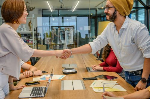Free Diverse team in a modern office engaged in a collaborative meeting, sealing a partnership with a handshake. Stock Photo