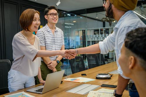 Free A diverse group having a productive business meeting with handshakes and smiles in a modern office. Stock Photo