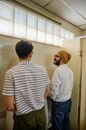 Man in White and Black Striped Polo Shirt Standing Beside Man in Gray Shirt