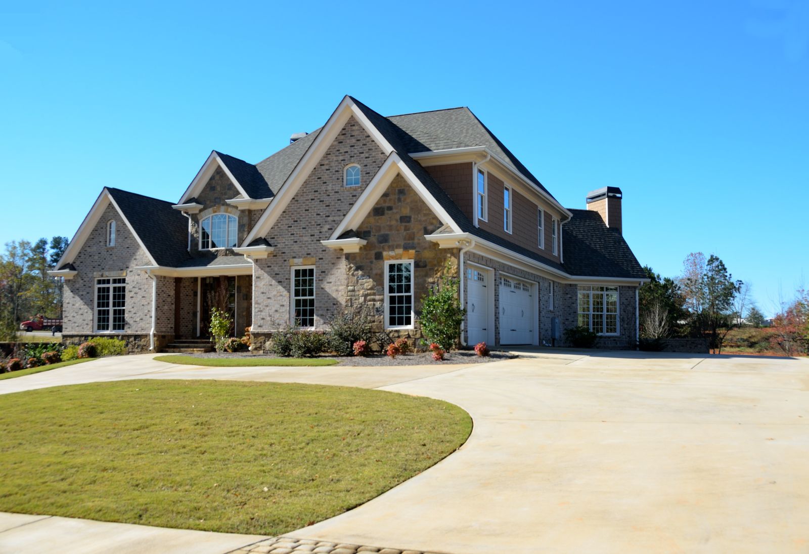 Large brick-and-stone two-story estate with multiple gables and a three-car garage on a curved driveway, Kinloch, Naperville IL