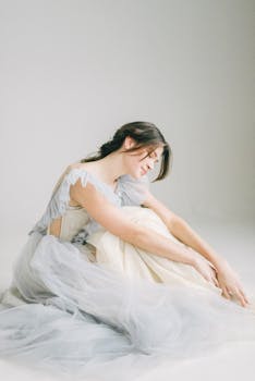 一位优雅的女性身着飘逸的连衣裙，在柔和的灯光下摆出姿势，非常适合时尚与生活方式的意象