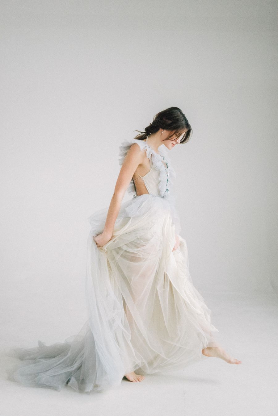 Bride in a flowing couture gown in soft studio light