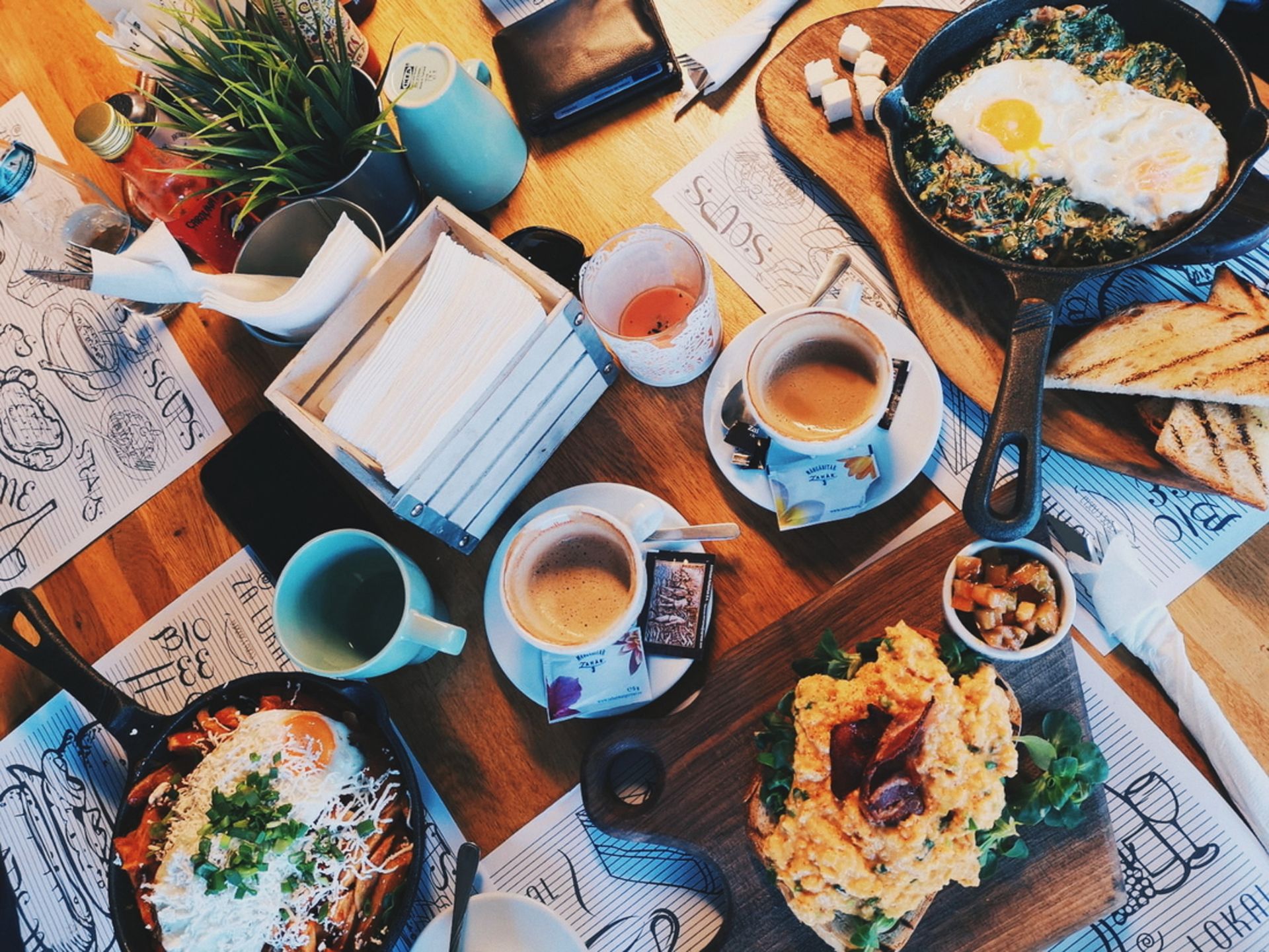 Overhead view of a Romanian breakfast spread with coffee, eggs, and colorful dishes in Bucharest.