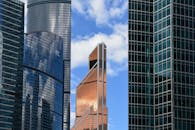 当代摩天大楼的反射玻璃立面映衬在蓝天下