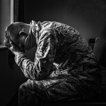 一幅黑白图像中，士兵沉思的倒影传达出情感与情绪