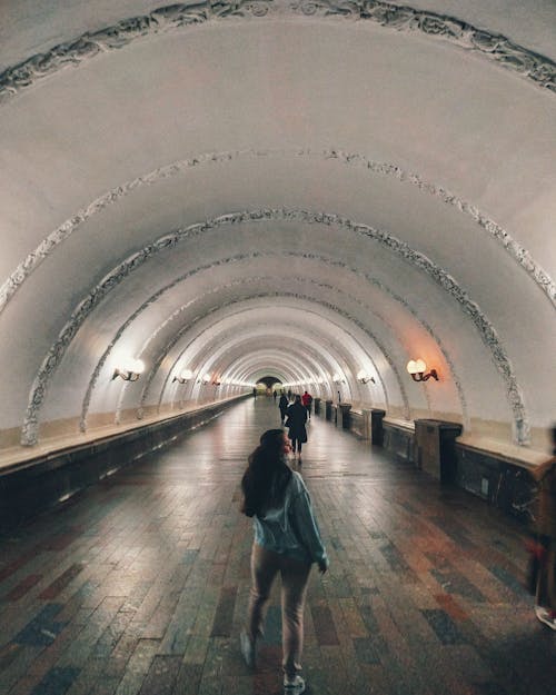 Anonymous woman walking in underground passage