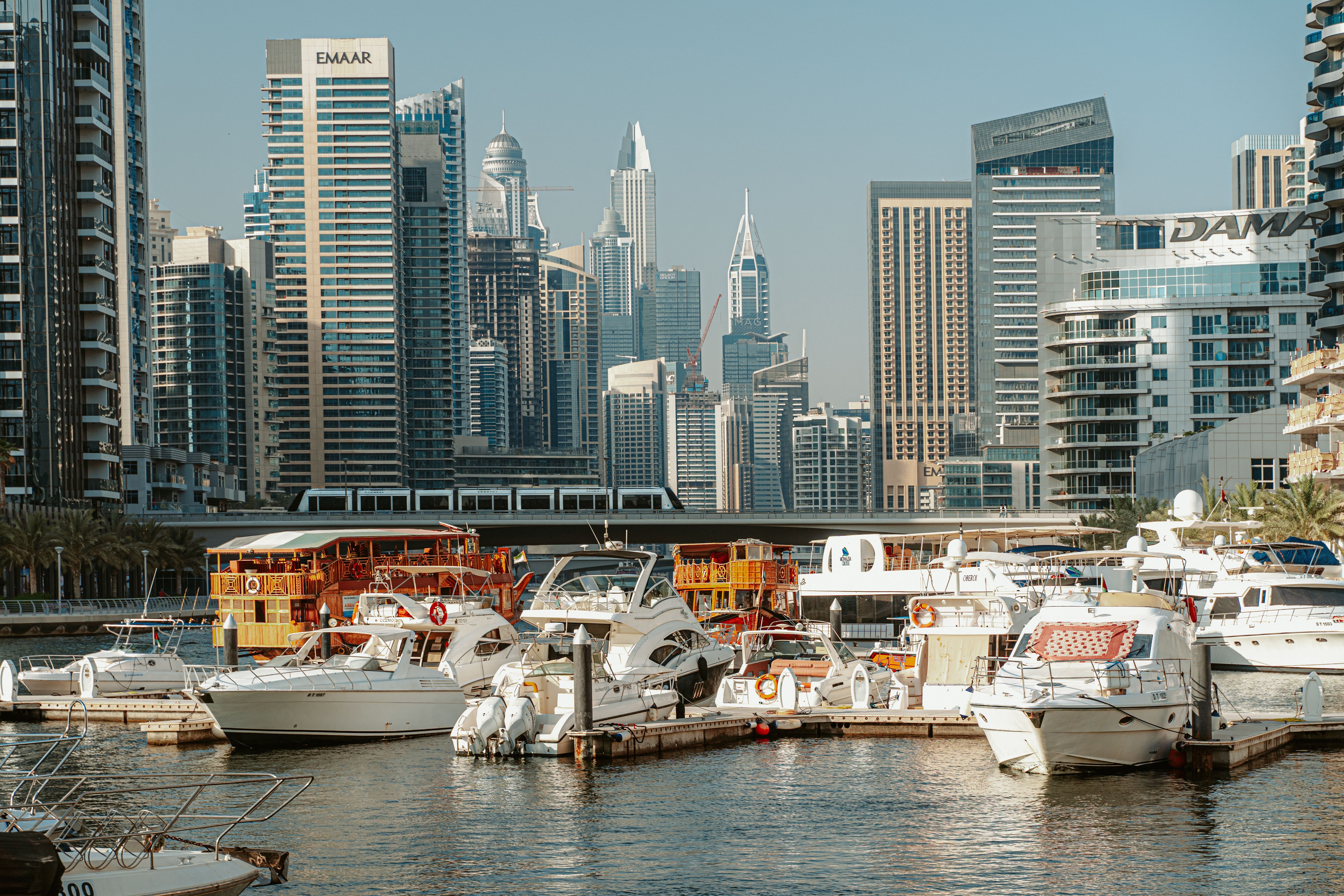 A stunning view of Dubai Marina with modern skyscrapers and yachts under a clear sky.