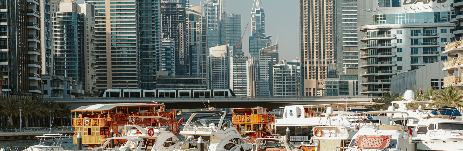 A stunning view of Dubai Marina with modern skyscrapers and yachts under a clear sky.