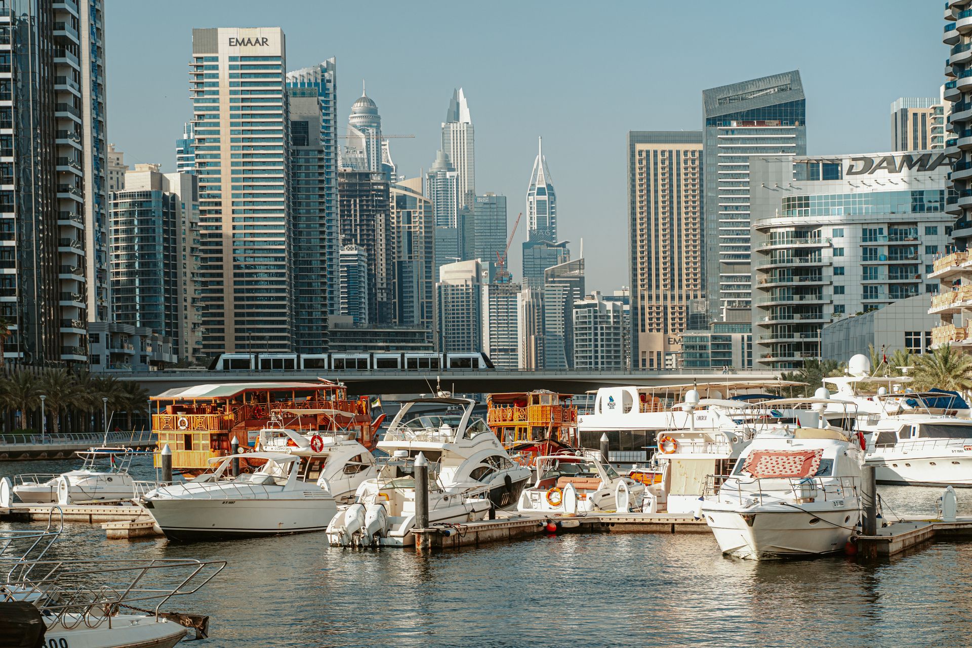 A stunning view of Dubai Marina with modern skyscrapers and yachts under a clear sky.