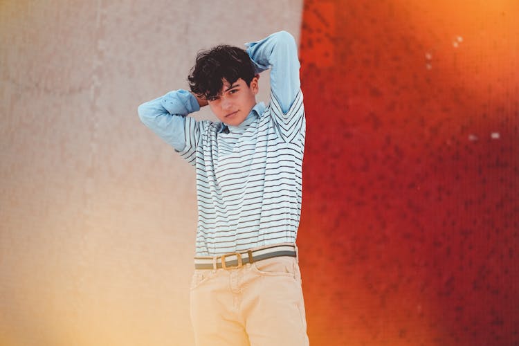 Confident Teen Boy With Hands Behind Head On Street