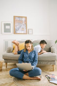 A mother and son enjoy a quiet day indoors, working and reading on the couch.