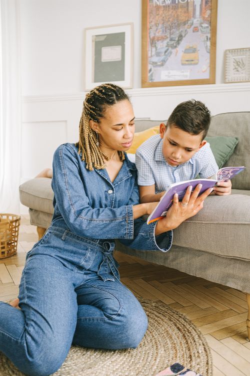 Free Mother and son enjoying quality reading time together indoors. Stock Photo