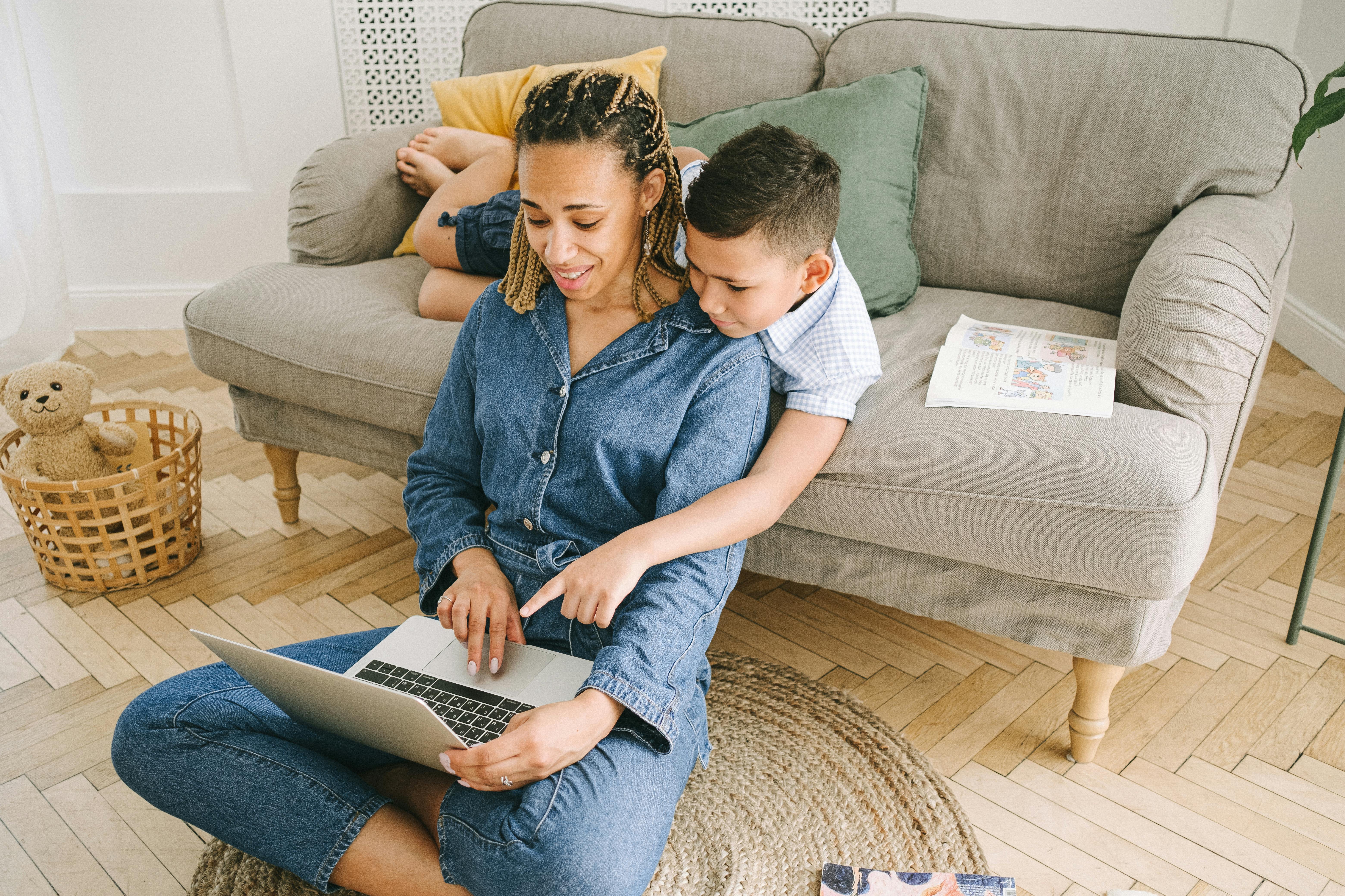 a mother using a laptop with her son