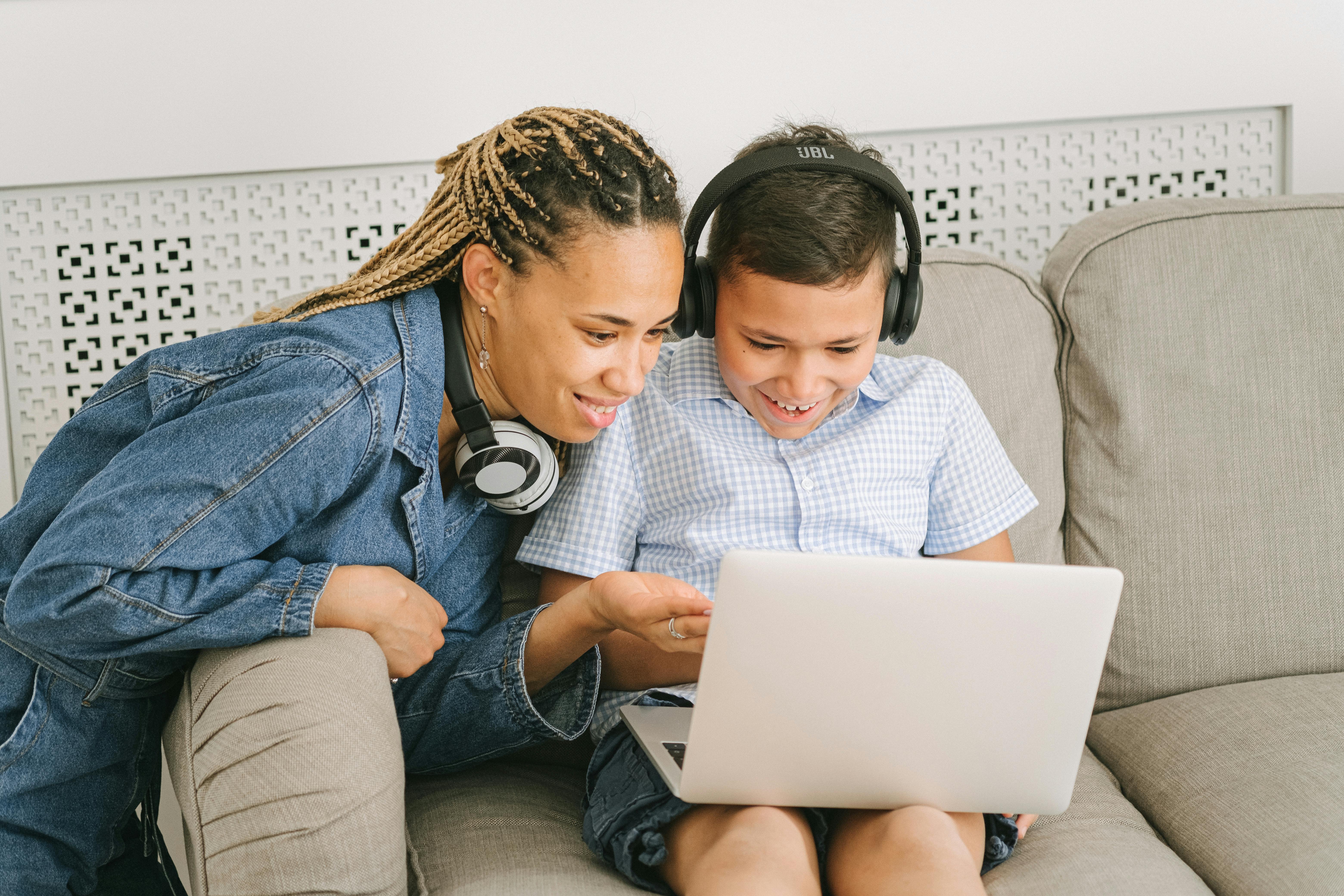 man and woman sitting on sofa using macbook