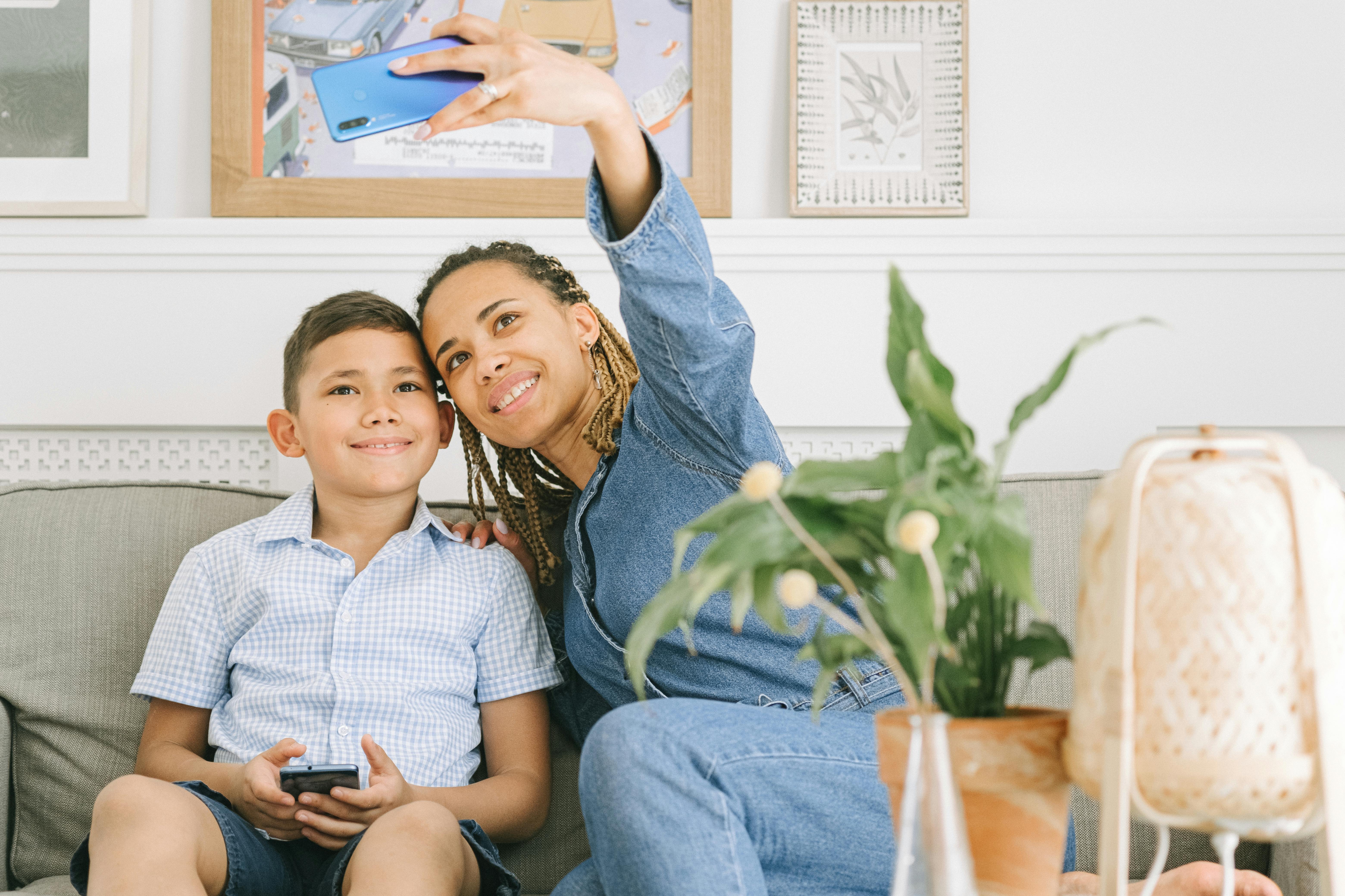 Free Woman in Blue Denim Jacket Taking a Selfie with Boy in Blue Button Down Polo Stock Photo