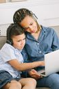 Woman and Boy with Head Phones Using Laptop Computer