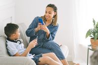 Woman in Blue Denim Jumpsuit Taking Photo of Boy