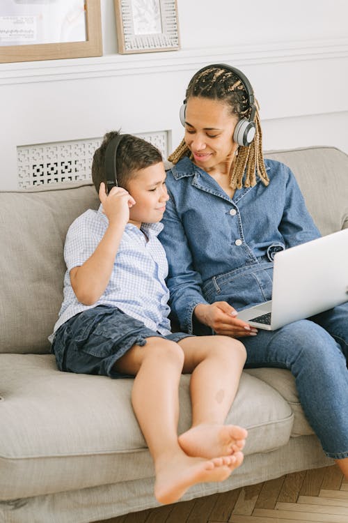 Boy and Woman Sitting on Sofa with Headphones