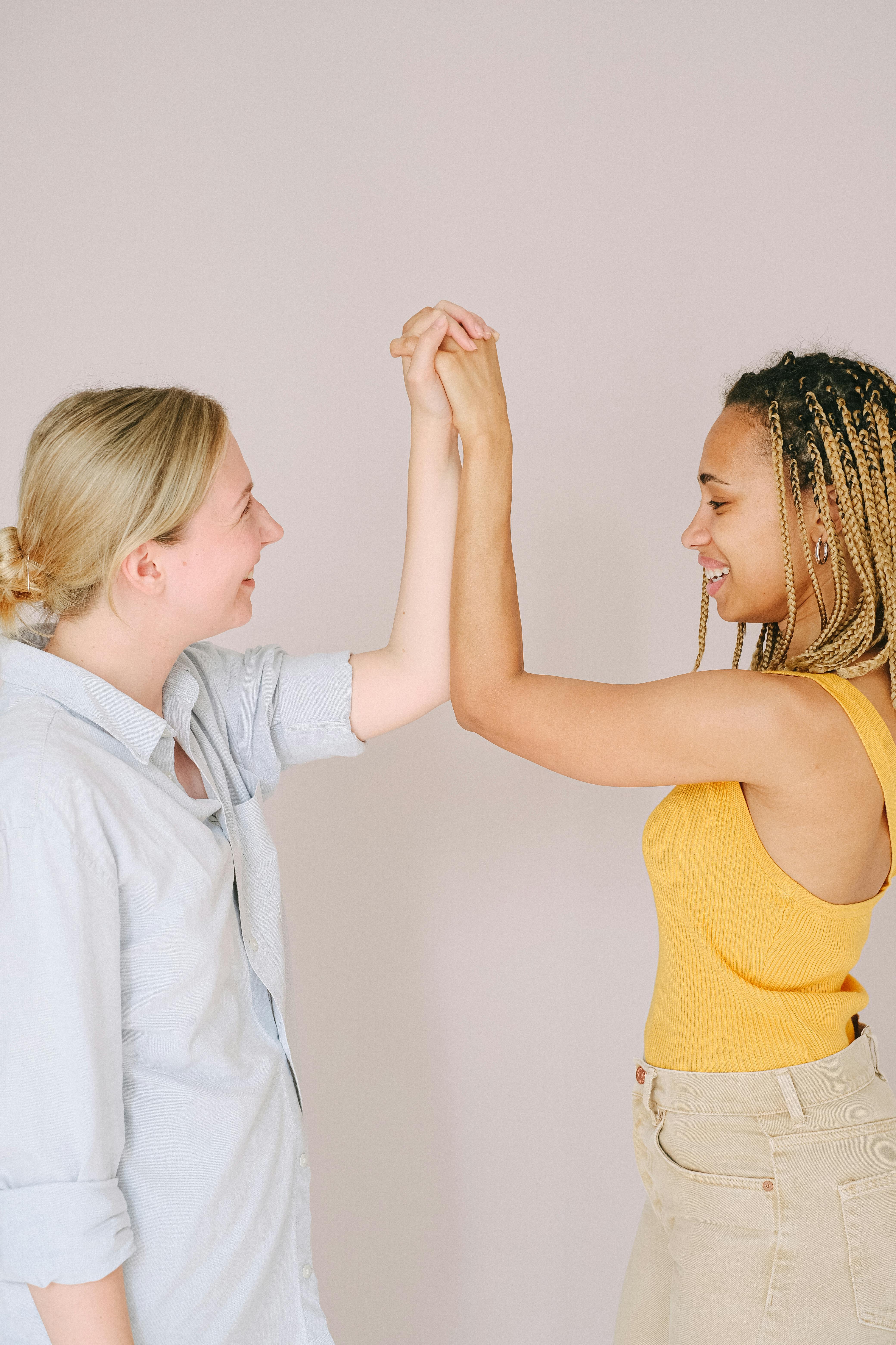 woman in yellow tank top holding girl in white shirt