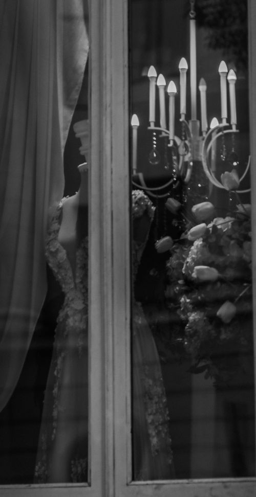 Free Black and white of artificial ma mannequin and chandelier with burning lamps through window Stock Photo