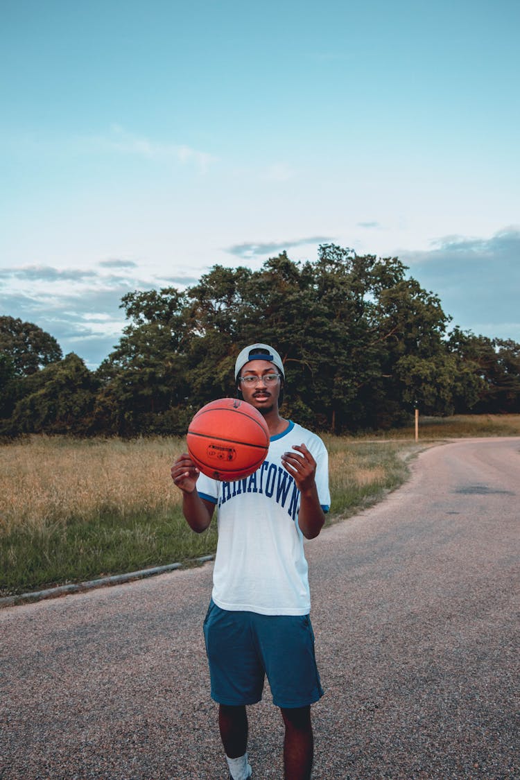 Dreamy Black Sportsman With Basketball On Roadway