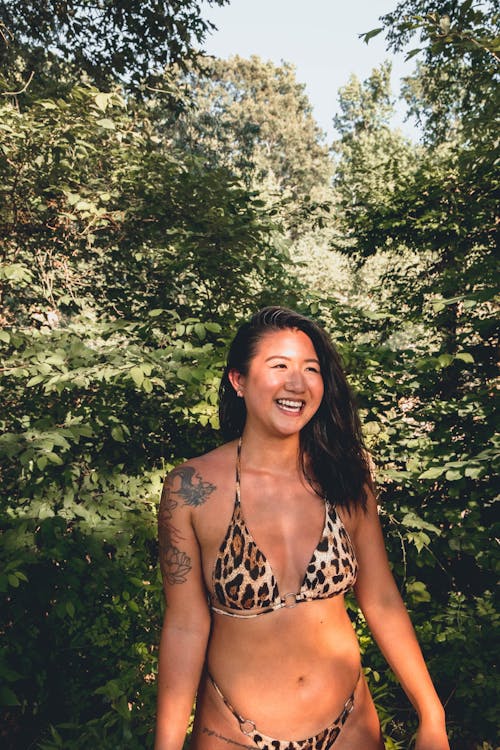 Young ethnic joyful woman smiling brightly standing in nature