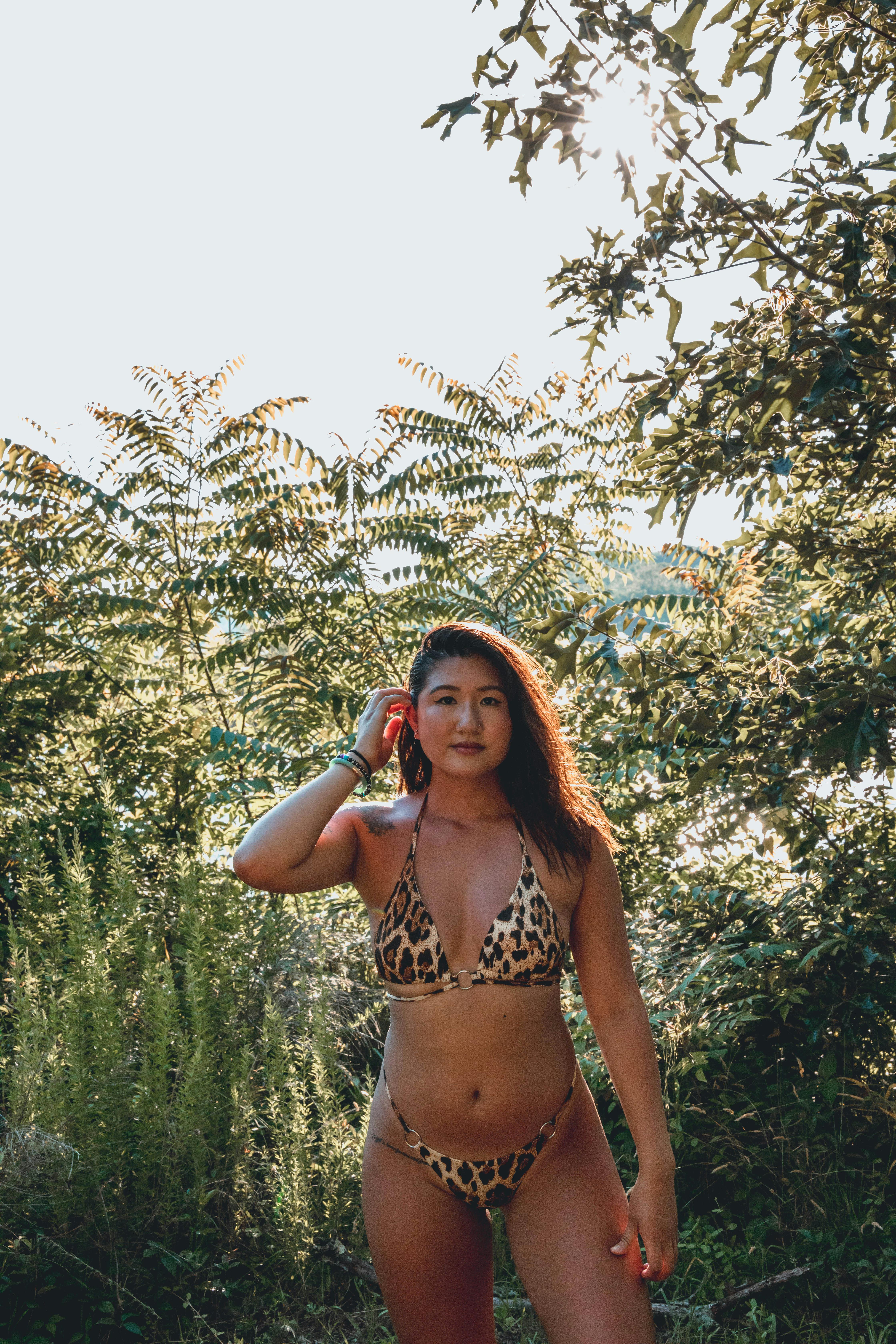 confident young ethnic in bikini against tropical trees