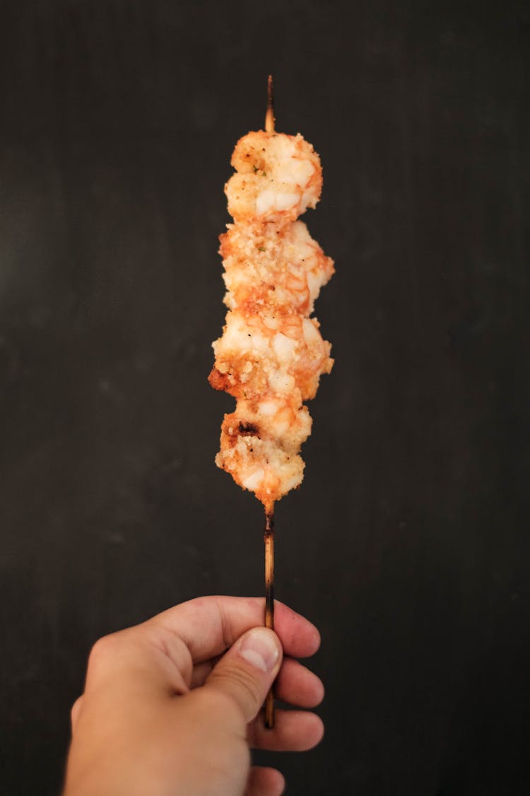 Crop Man With Grilled Skewer Meat Against Black Wall