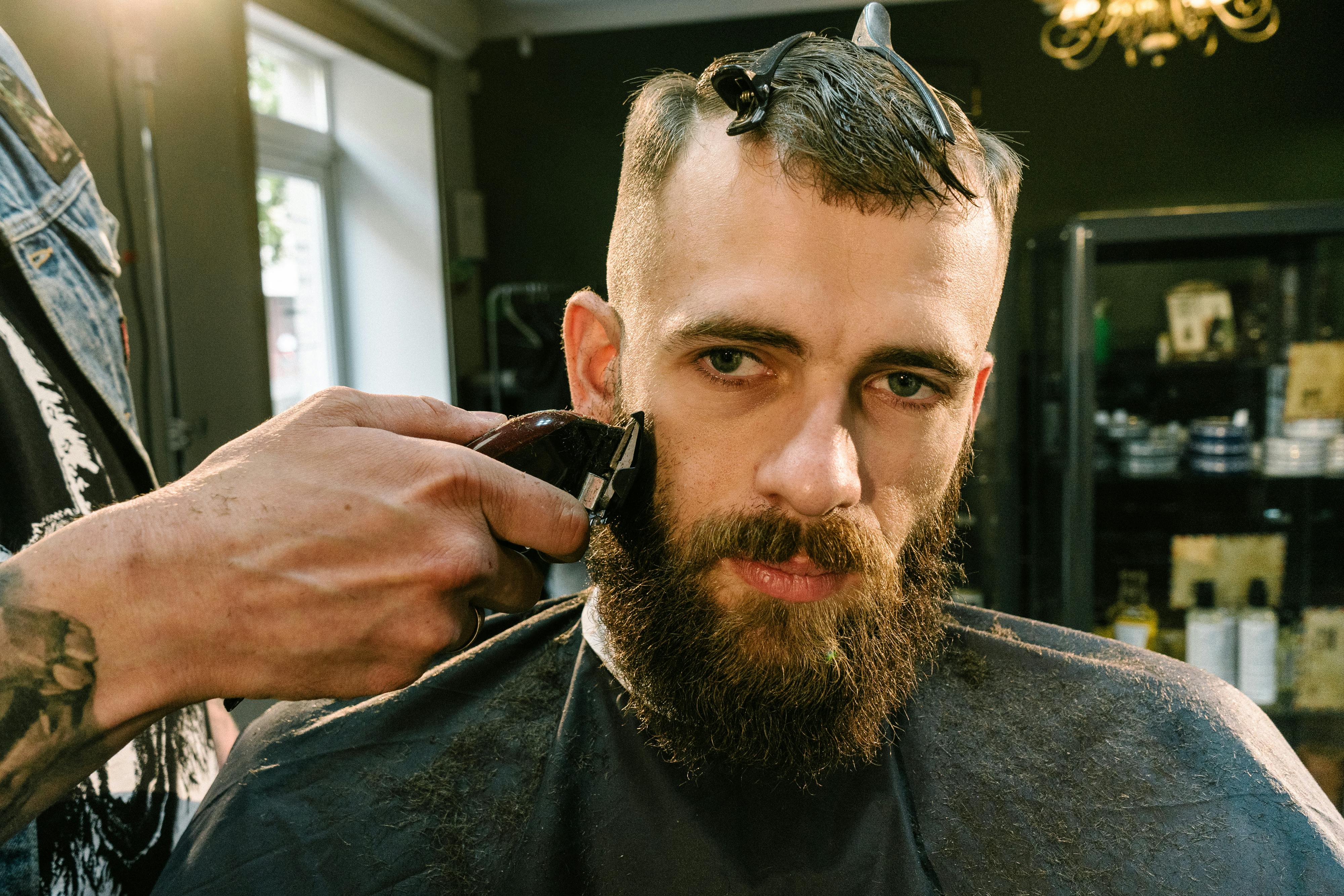 a barber shaving a man s beard