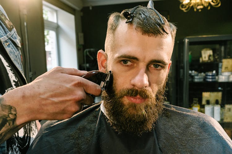 A Barber Shaving A Man's Beard