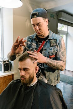 A skilled barber trims a man's hair in a trendy barbershop setting.