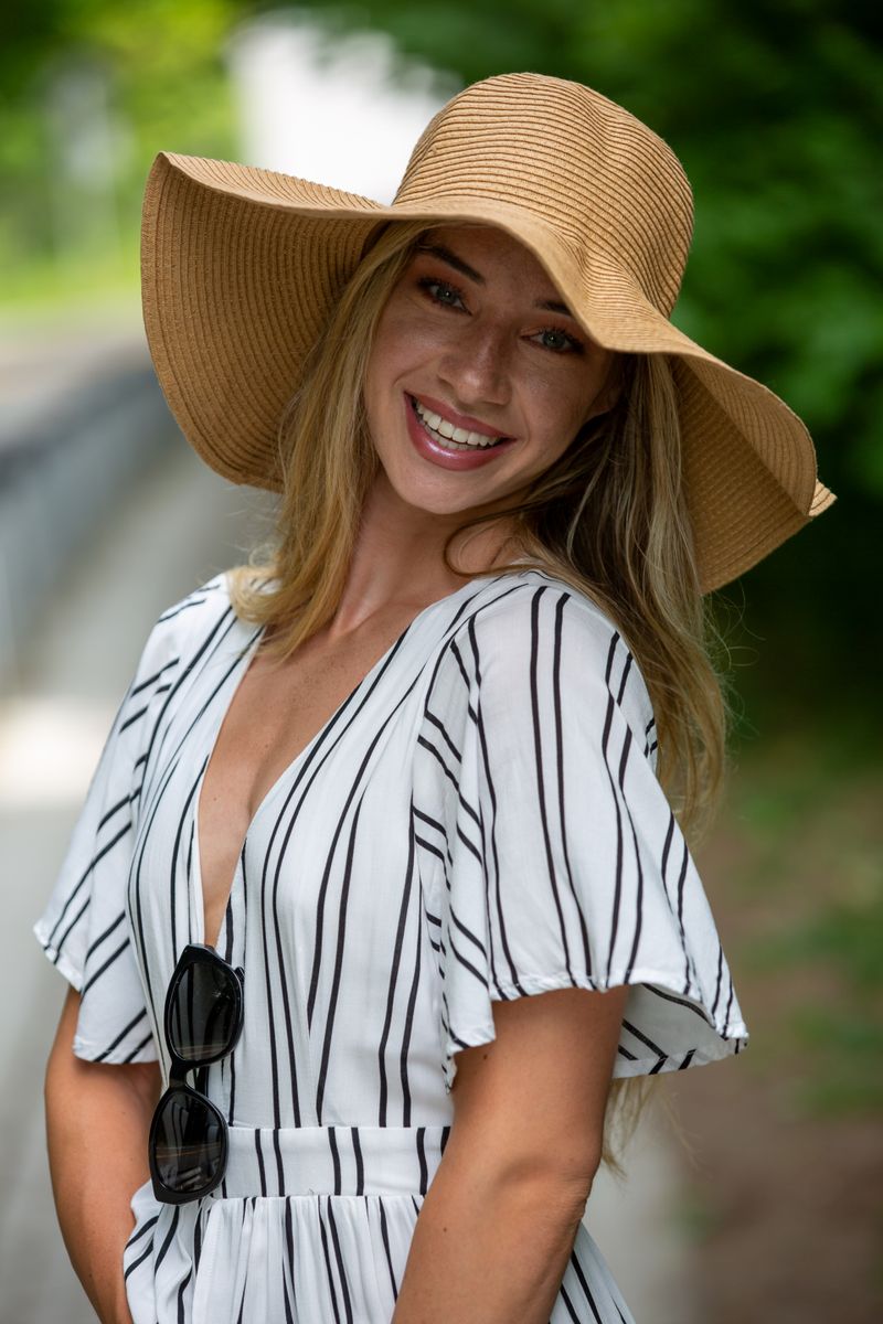 Woman in a striped dress and sun hat at the park