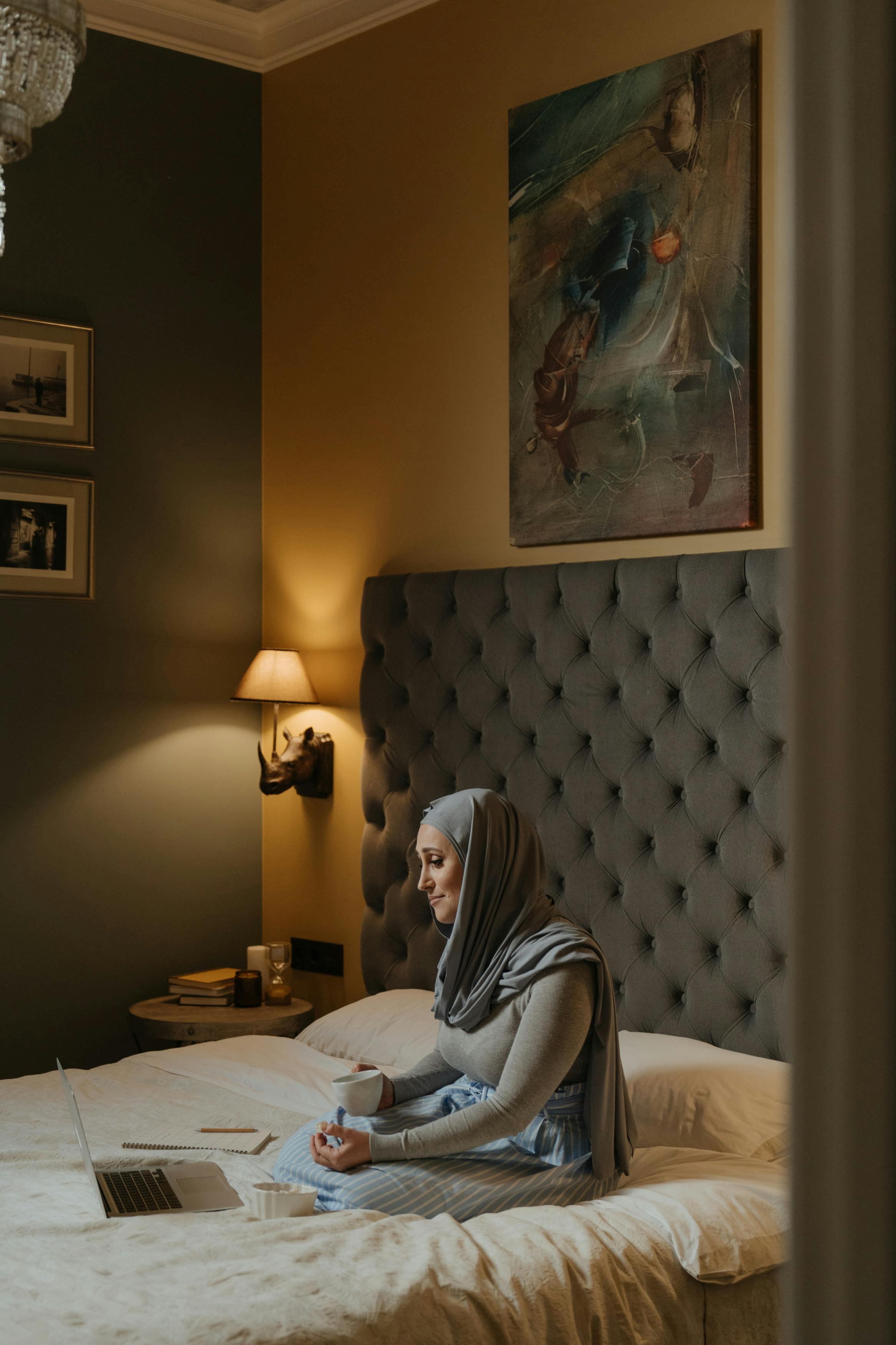 woman in gray hijab using laptop