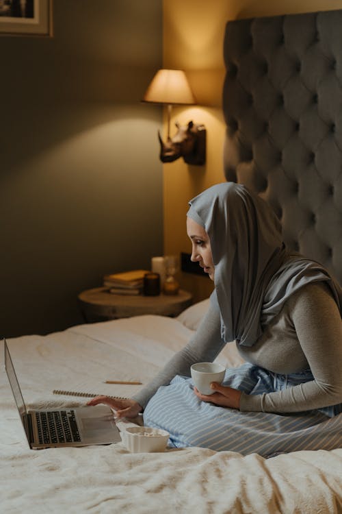 Donna In Hijab Grigio Che Si Siede Sul Letto