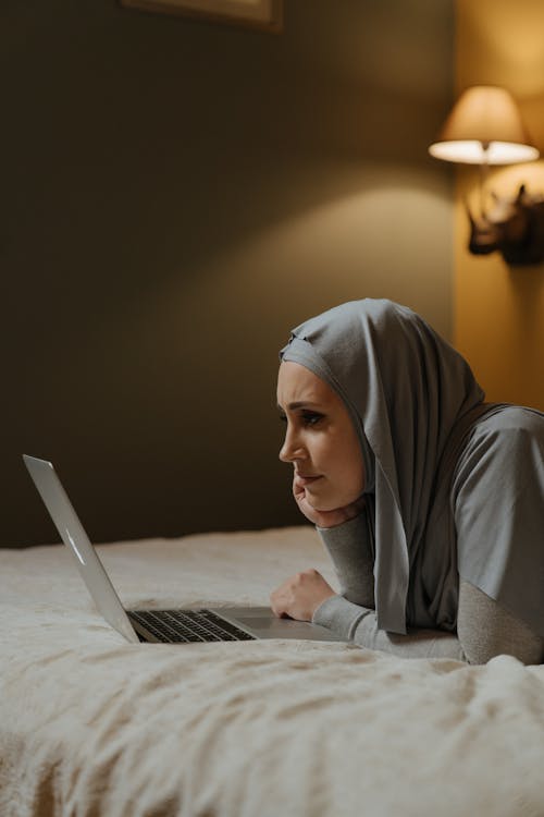무료 Macbook Air를 사용하는 회색 Hijab의 여자 스톡 사진