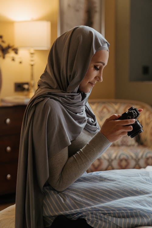 Woman in Gray Hijab Holding Black Dslr Camera
